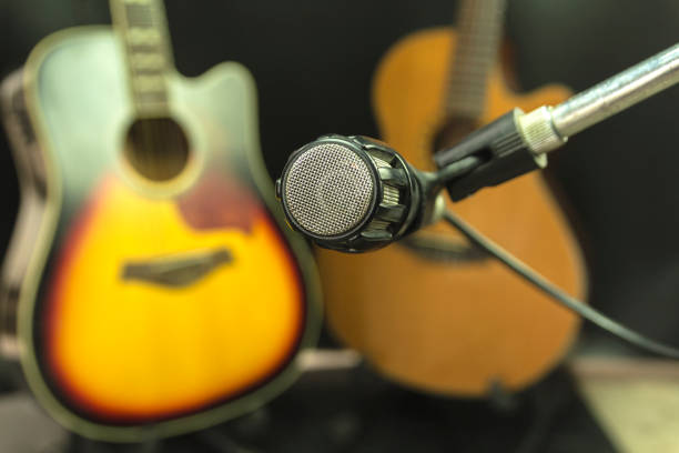 istock Microphone in music room, guitar and black background scenes 858034012