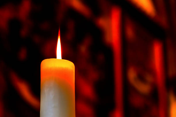 istock Red flame of a wax candle gives beautiful light and shadows. 858034612