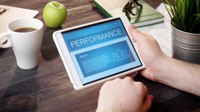 Checking performance info using digital tablet at desk