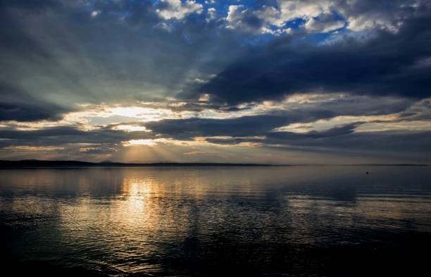 istock sun over the lake shines through the gray clouds 858042922