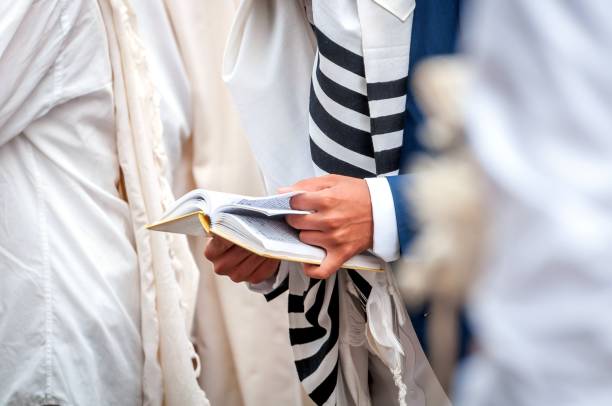 prière. hassid en vêtements traditionnels. tallith - châle de prière juif. mains tenir un livre de prières. gros plan. - judaism jewish ethnicity hasidism rabbi photos et images de collection