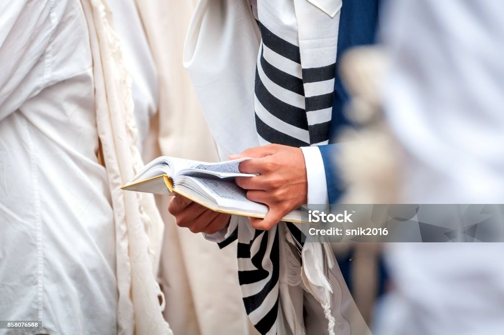 Prayer. Hasid in traditional clothes. Tallith - jewish prayer shawl. Hands hold a prayer book. Close-up. Prayer. Jew. Rabbi Stock Photo