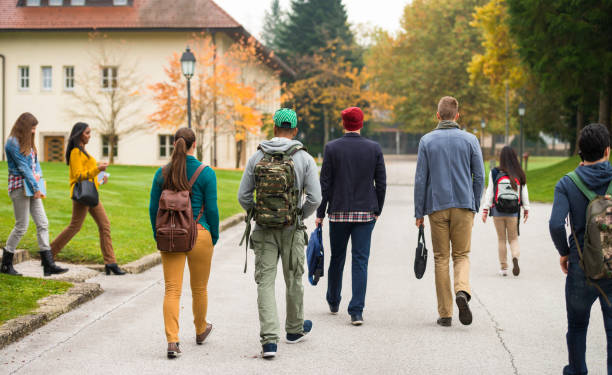 istock Rear View Of Students Walking Through The Park 858079302