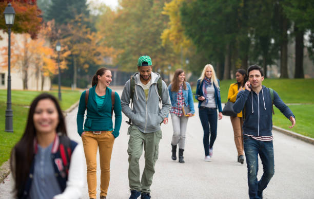 studenti che camminano attraverso il parco - campus autumn walking university foto e immagini stock