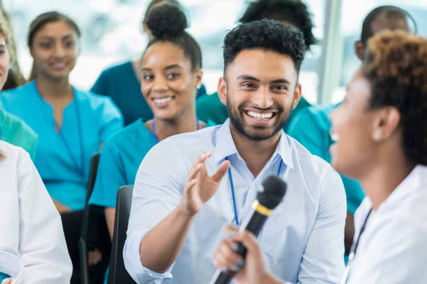 istock Cheerful young man asks question during medical seminar 858087782