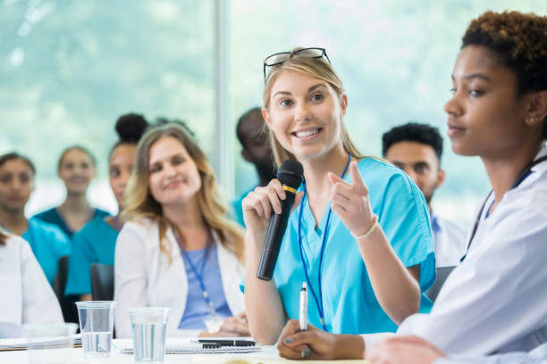 istock Pretty female doctor asks question during healthcare conference 858087796