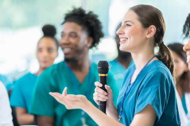 istock Cheerful female nurse asks question during healthcare seminar 858087800