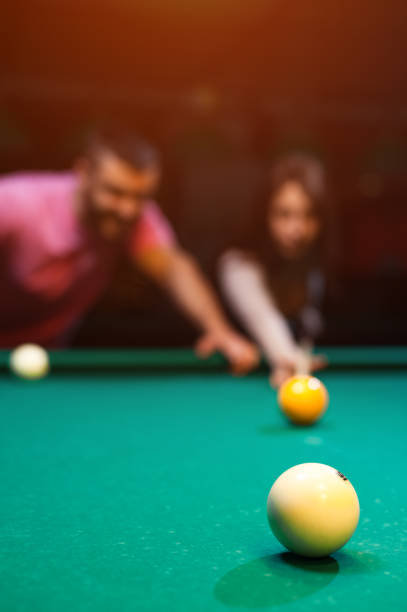 istock Romantic couple playing billiard in dark club 858091402