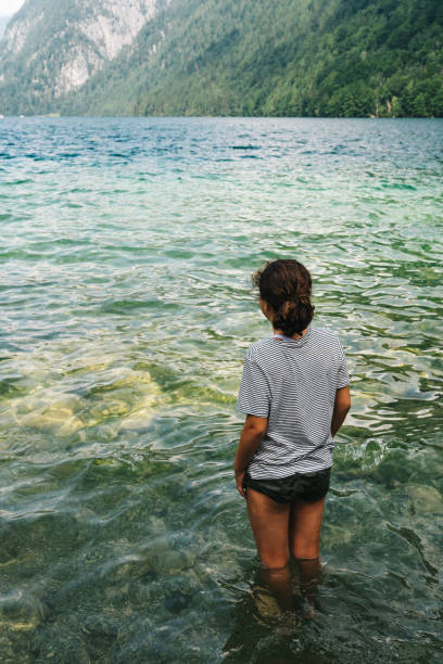 istock Young woman getting dressed into the water at beautiful lake 858094968