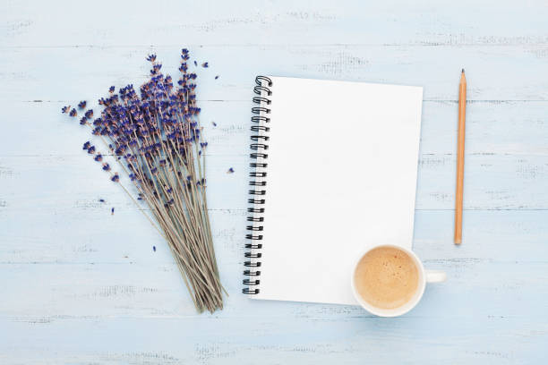istock Fresh coffee, clean notebook and lavender flower on blue background from above. Woman working desk. Cozy breakfast. 858109976