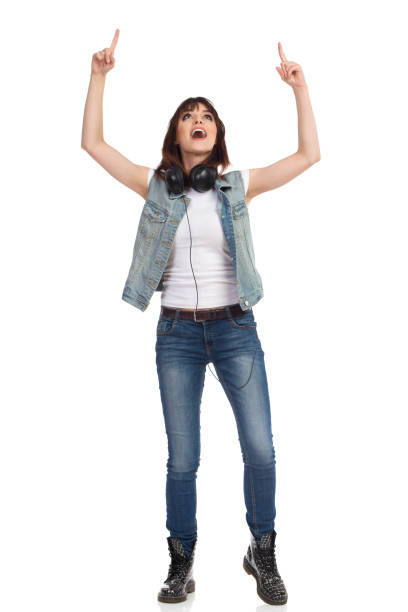 istock Young Woman In Jeans Unbuttoned Vest Is Standing, Pointing Up And Talking 858110670