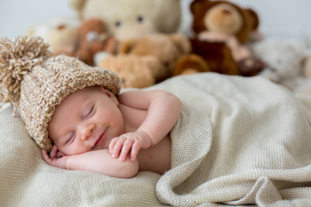 Little newborn baby boy, sleeping with teddy bear at home in bed Little newborn baby boy, sleeping with teddy bear at home in bed, infant resting with toy baby mice stock pictures, royalty-free photos & images