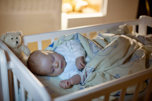 istock Adorable newborn baby boy, sleeping in crib at night 858111920
