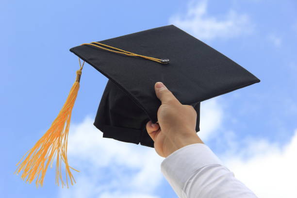 istock Male hand throwing graduation hat in the air 858112220