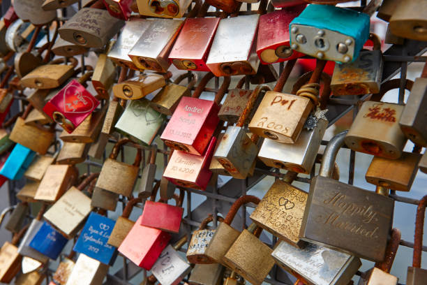 istock Colored rusted padlocks chained on a bridge handrail. Romantic 858118448