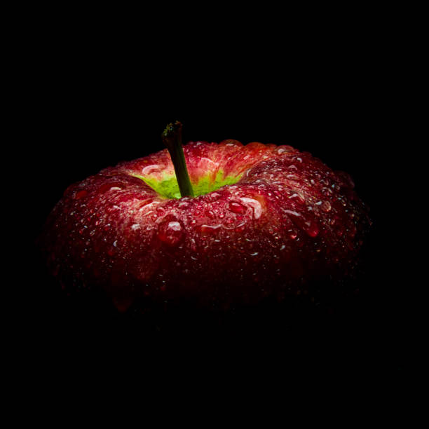 istock Water droplet on glossy surface of red apple on black background 858119148