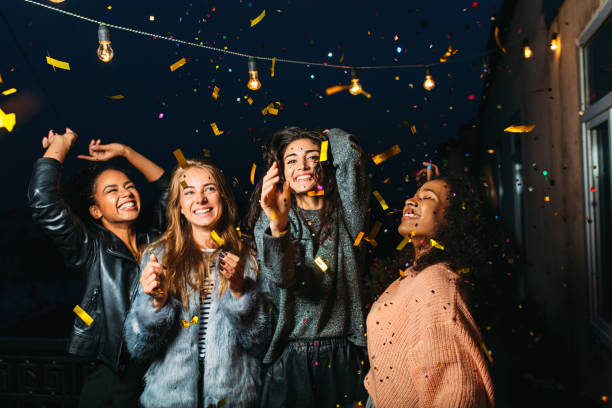 istock Night party on a terrace. Happy women having fun under confetti. 858123364