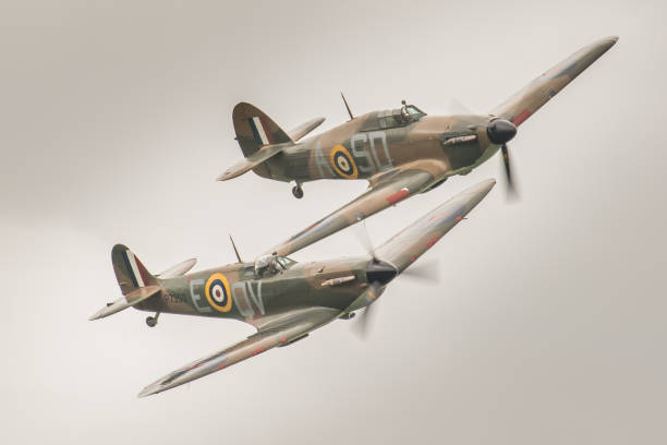 Hurricane & Spitfire - Battle of Britain / WWII fighter aircraft Old Warden, UK - June 4th, 2017: a Hawker Hurricane and a Supermarine Spitfire WWII fighter aircraft of the Royal Air Force's Battle of Britain Memorial Flight pictured in flight over Bedfordshire, England. spitfire stock pictures, royalty-free photos & images