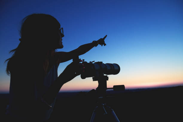 istock Silhouette of a girl while watching through the telescope. 858127910