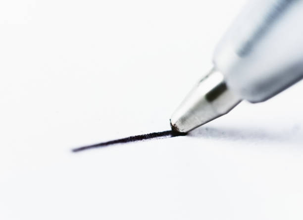 istock Macro look at ballpoint pen drawing black line on white 858130824