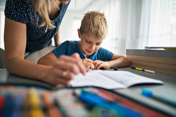 hijo de madre ayudando a hacer su tarea - homework fotografías e imágenes de stock