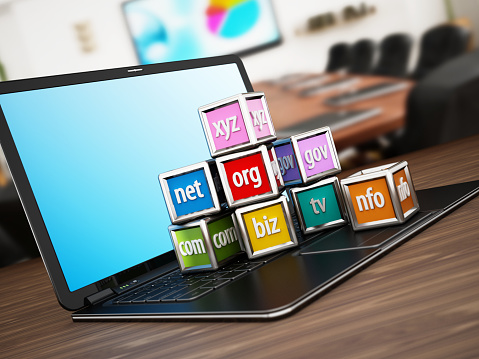 Vibrant colored cubes with domain name extensions standing on laptop computer. Background image is from my own portfolio.