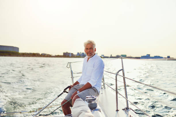 istock Mature man sailing his yacht on the open water 858136966