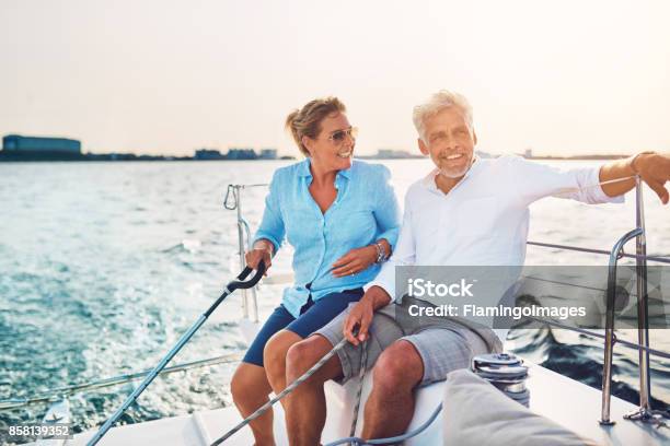 Smiling Mature Couple Enjoying A Sunny Day Sailing Together Stock Photo - Download Image Now