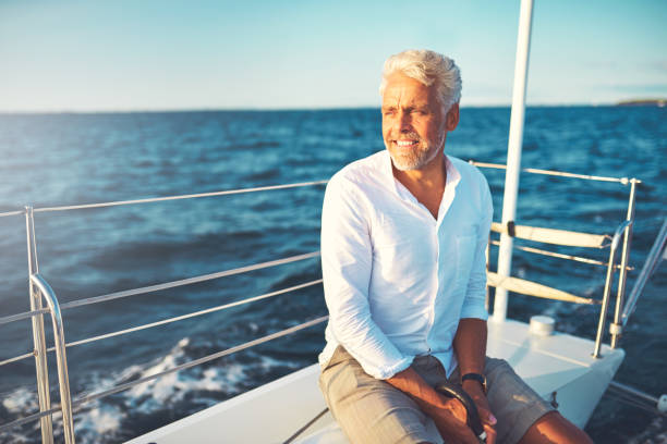 istock Smiling mature man sailing his boat alone on the ocean 858139730
