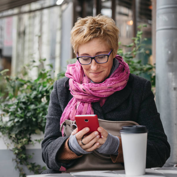 istock Smiling woman with phone in cafe 858143390