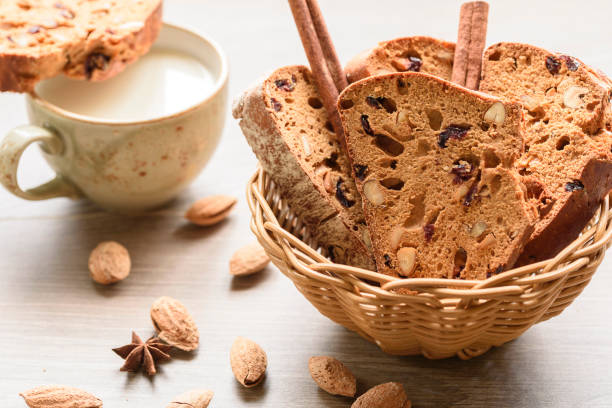 木製のテーブル上のナッツで飾られた伝統的なイタリアのビスコッティ バスケットにアーモンド cantuccini - cookie biscotti italian culture variation ストックフォトと画像