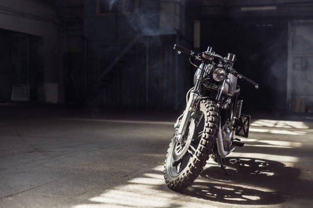 motorcycle standing in dark building in rays of sunlight