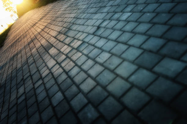 istock Gray paving stone path goes away the prospect in sunset 858151506