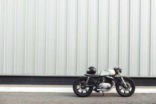 Vintage motorcycle standing in a dark building in the rays of sunlight. Side view