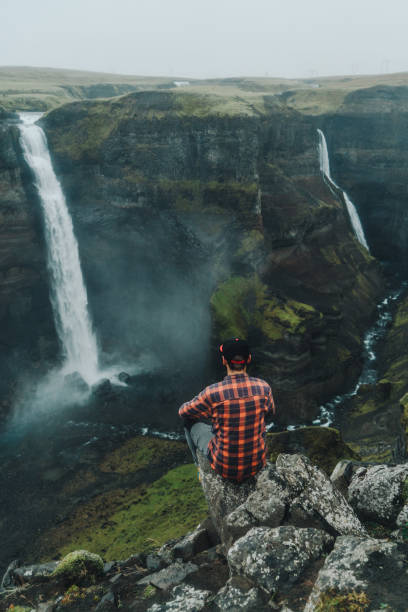 istock Man sitting  near Haifoss   waterfall in mountains 858152778