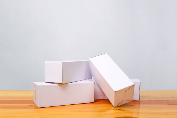 istock Empty four Package white cardboard box for long items on wooden table with copy space. 858160916