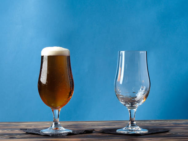 istock Empty glass and a glass of light beer on a blue background. 858163750