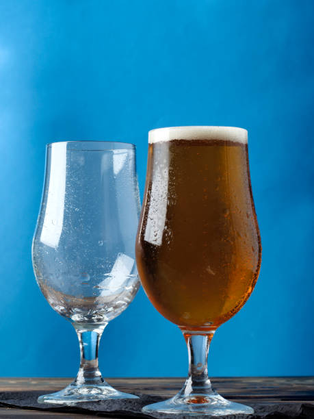 istock Empty glass and a glass of light beer on a blue background. 858163770