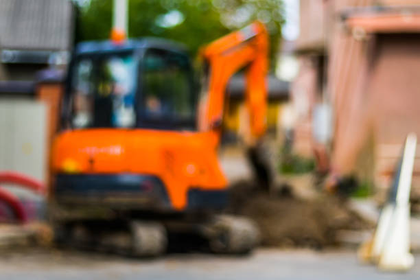 istock Abstract blurred background  - small excavator with man inside, at work making street repair 858164384