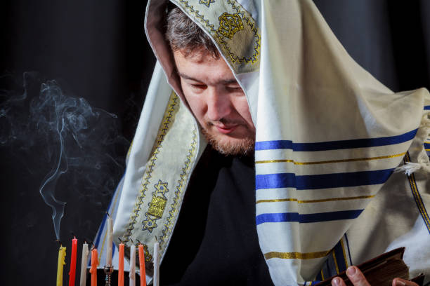 istock man lighting candles in menorah on table served Hanukkah 858168560