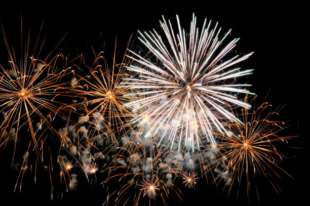 istock Golden and white fireworks display on dark sky background 858172612