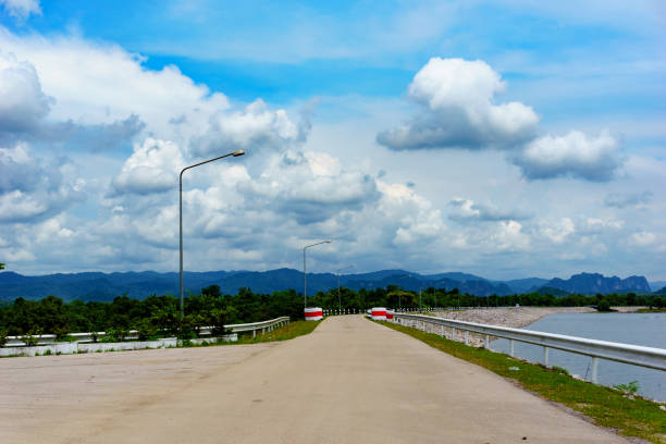 istock road along the dam with cloudy blue sky. journey or milestone abstract concept. 858177172