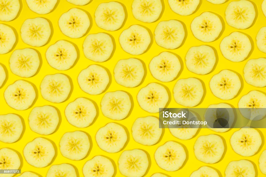 Slices of fresh bananas on yellow background. bananas pattern on yellow background. Abstract background with slices of fresh bananas. Banana Stock Photo