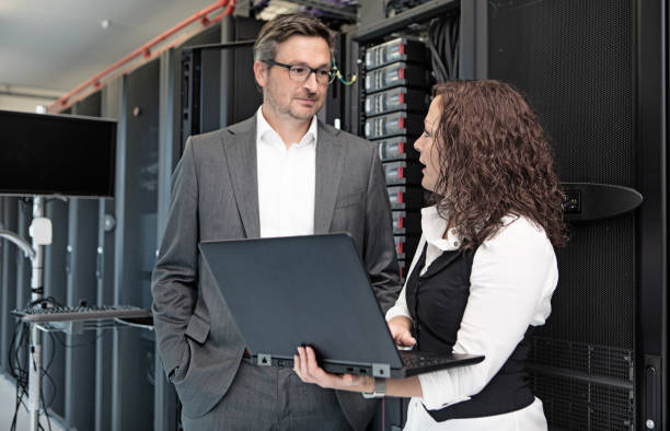 istock Adult Male manager and Female Technician working in Server Room Setting 858177276