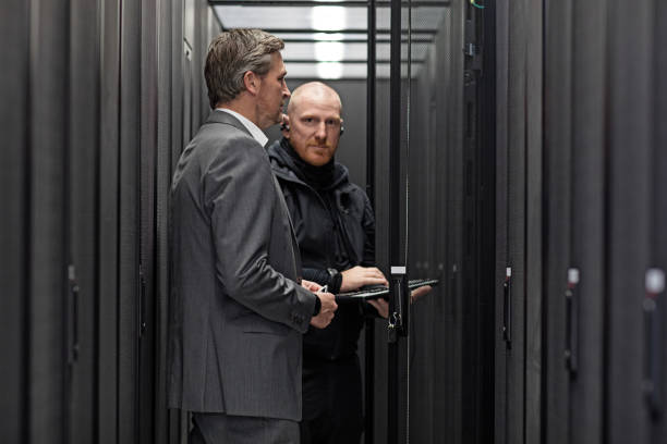 istock Male Adult Technicians and Manager working together in Server Room Setting 858177782