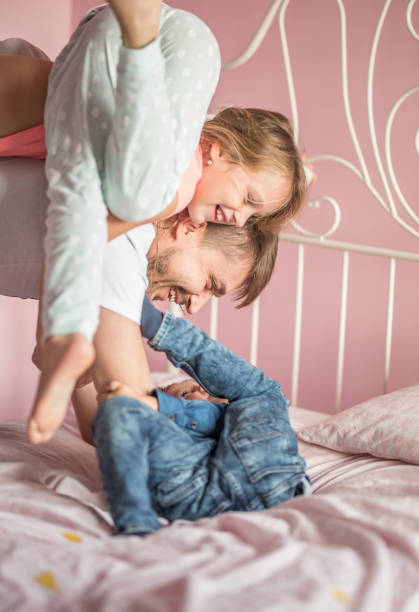 istock Father playing in bed with his son and daughter 858177984