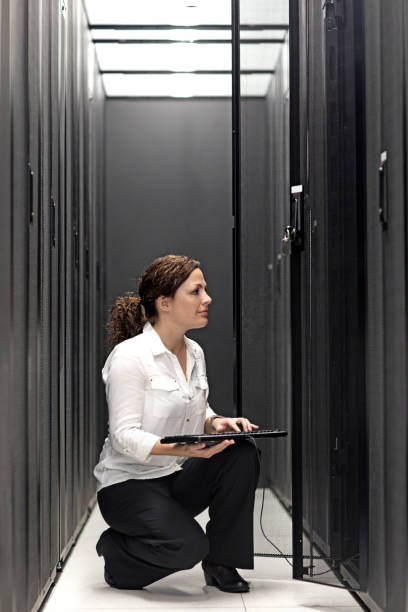 istock Adult Female Technician working in Server Room Setting 858178116