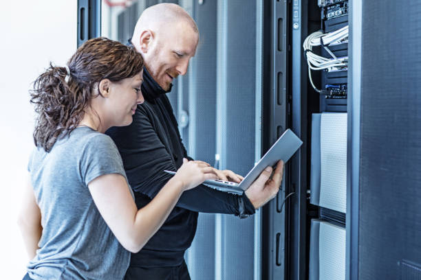 istock Male and Female Adult Technicians working in Server Room Setting 858178578