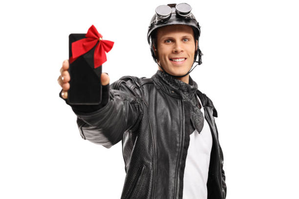 istock Biker showing a phone wrapped with a ribbon as a present 858180734