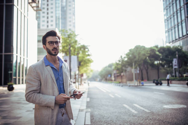 istock Man standing outdoors and holding phone 858181694